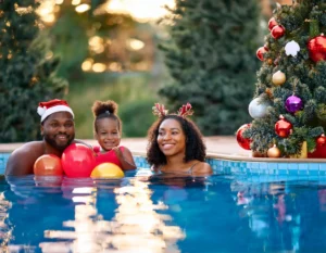 Família em bricadeiras de natal na piscina com crianças