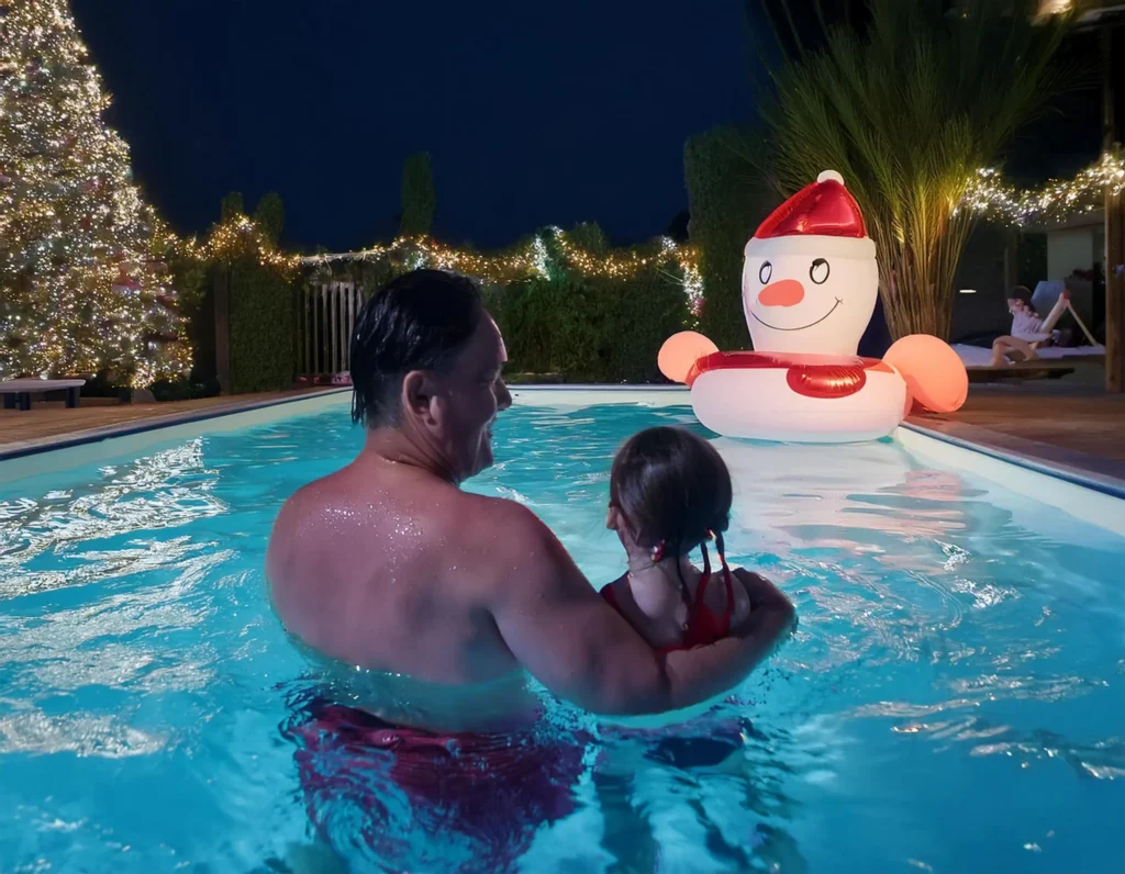 Pai e filha juntos em brincadeiras de natal na piscina