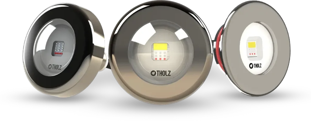 Tres reflectores de piscina Tholz en diferentes acabados metálicos, con iluminación LED integrada